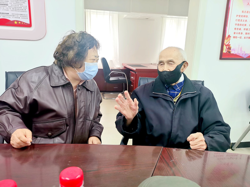 徐同昌(右)与所在党支部书记交流自己捐资助学的目的和初衷