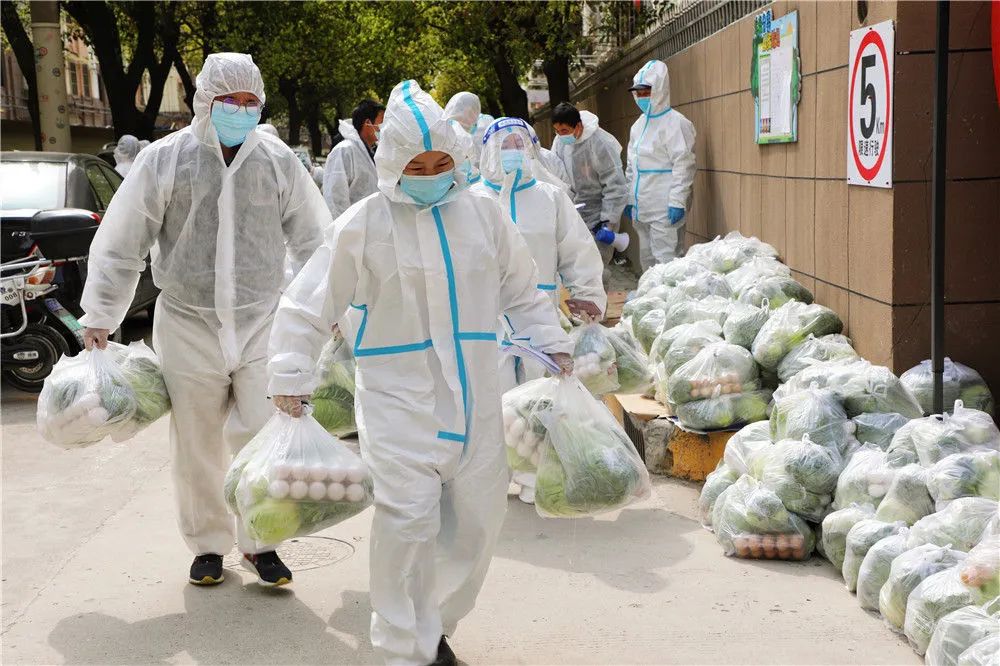 3月28日,上海市奉贤区西渡街道鸿宝一村(南区)的志愿者为居民送菜。新华社发(王燕婷 摄)