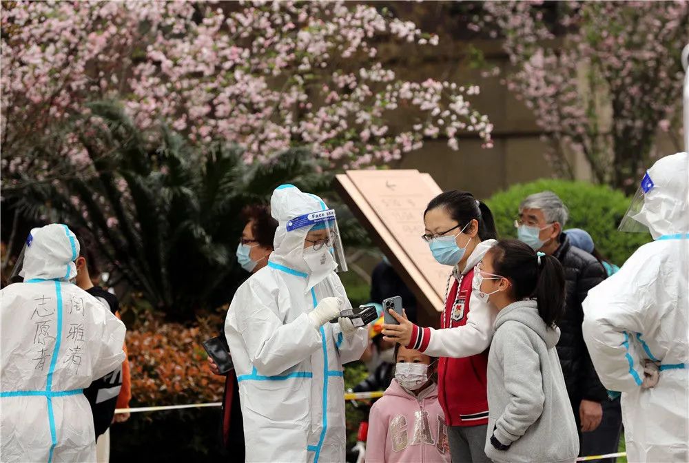 3月27日,在上海市松江区某封控小区内,志愿者为居民进行核酸检测登记。新华社记者刘颖摄
