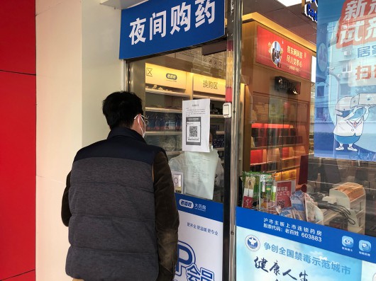 一名工作人员前来为居民配退烧药。