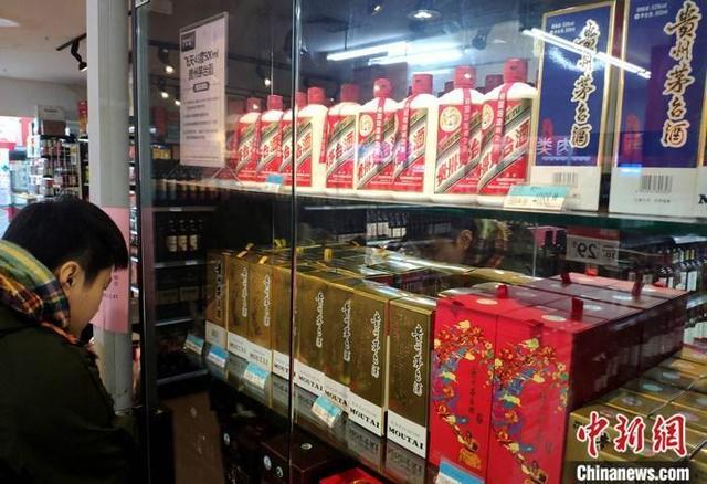 资料图:市民在福建福州的一超市贵州茅台酒专柜了解信息。 中新社记者 吕明 摄