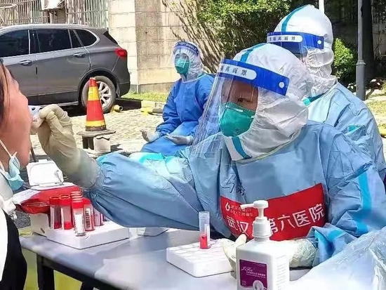 4月4日,武汉六院援沪医疗队的医护人员在为上海市民采集核酸。图片来源:武汉六院