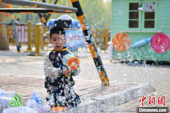 4月4日,小朋友在北京陶然亭公园玩泡泡枪。 中新社记者 田雨昊 摄