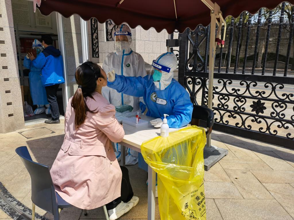 在上海市长宁区,一名武汉援沪医务人员正在为社区居民做核酸。(受访者供图)