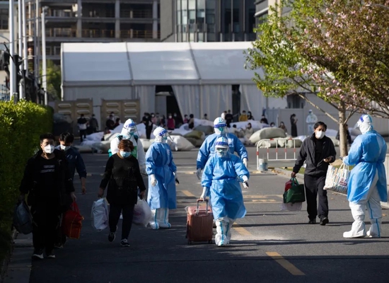 4月9日,在上海跨采中心方舱医院,第一批完成出院手续的四名康复者走出医院。金立旺摄(新华社)