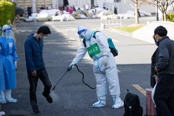 4月9日，在上海跨采中心方舱医院，工作人员为出院的康复者做消杀处理。新华社记者 金立旺 摄
