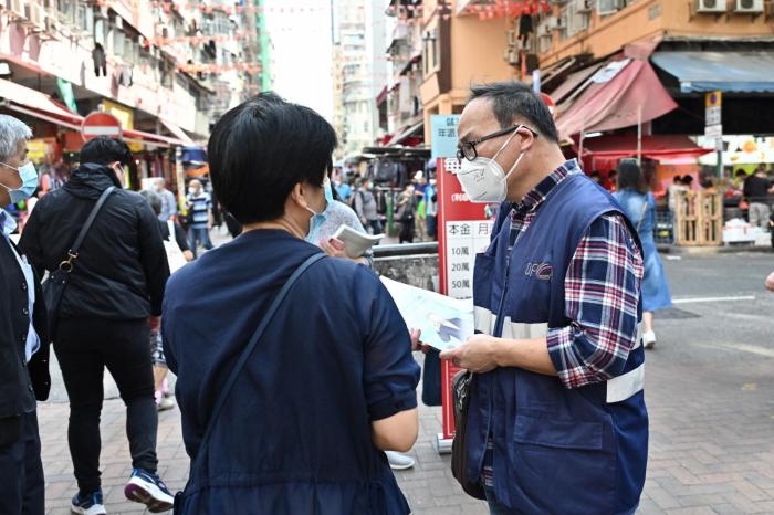 图示通讯办职员向市民派发宣传小册子。图片来源:香港特区政府新闻处