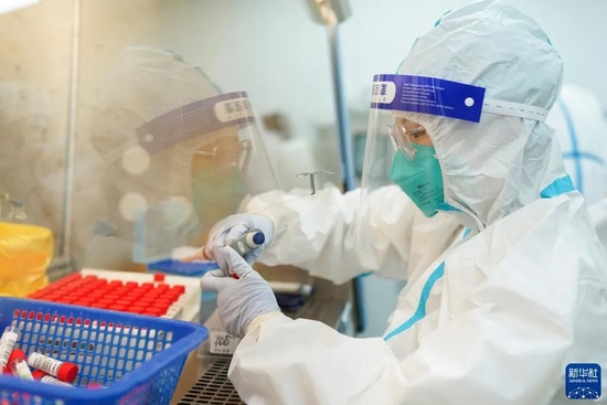 3月23日凌晨，同济大学附属同济医院内的核酸检测实验室灯火通明，工作人员紧张而有序地进行核酸检测工作。新华社记者 丁汀 摄