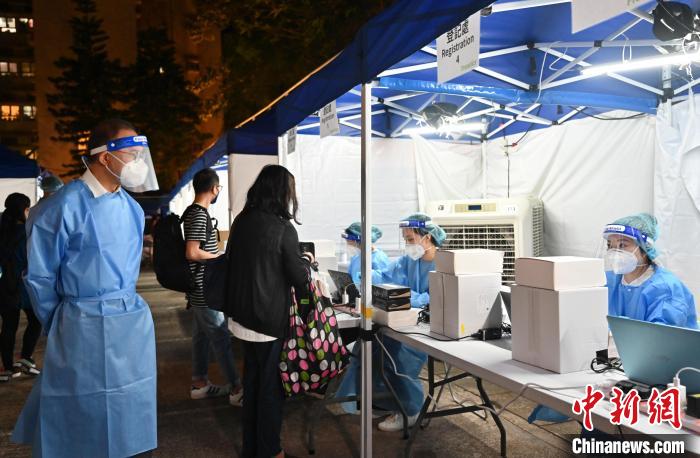 曾国卫(左)视察登记工作,并为同事打气。 香港特区政府新闻处供图