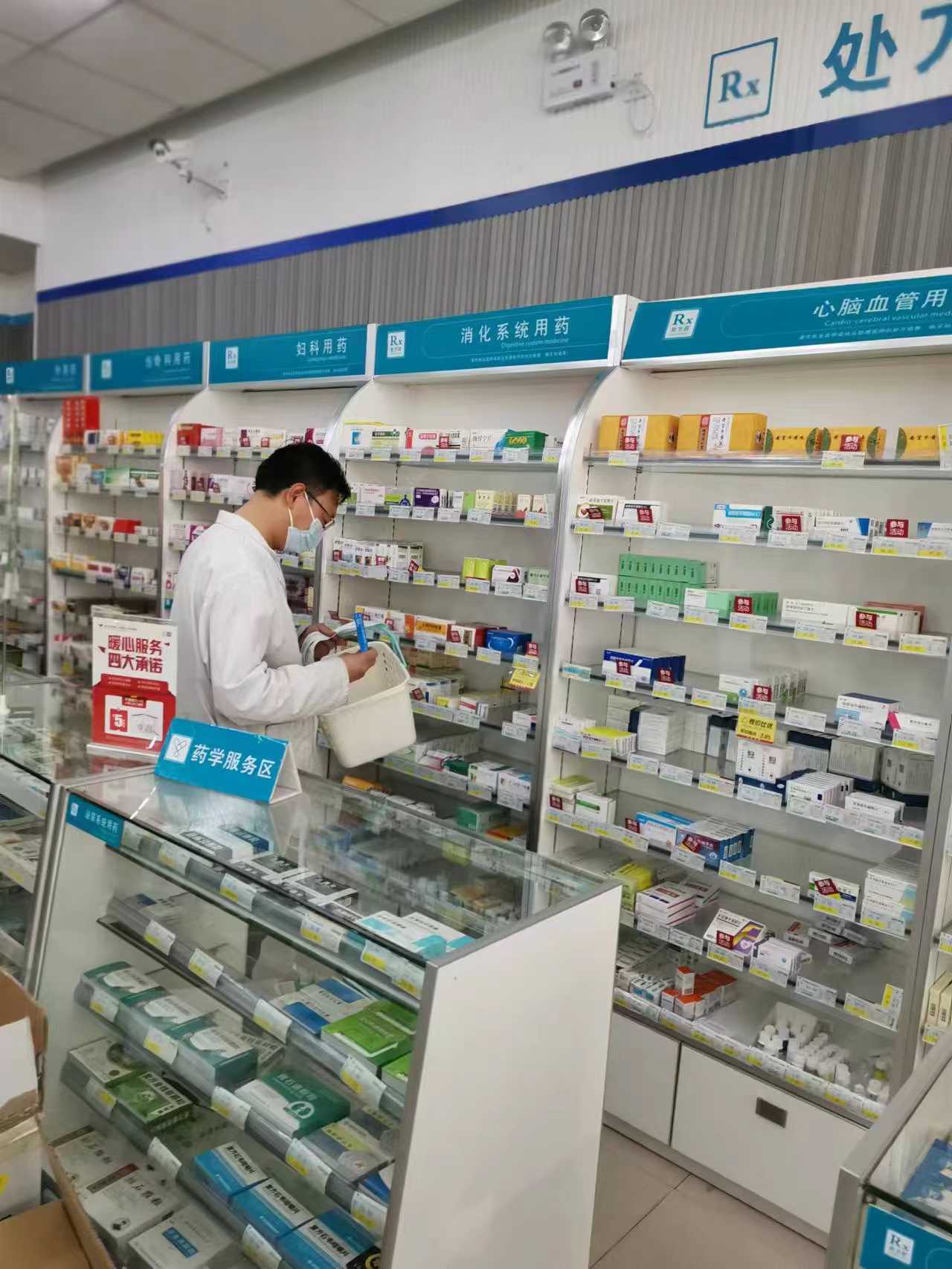 李中州在货架前根据订单拿药。受访者供图