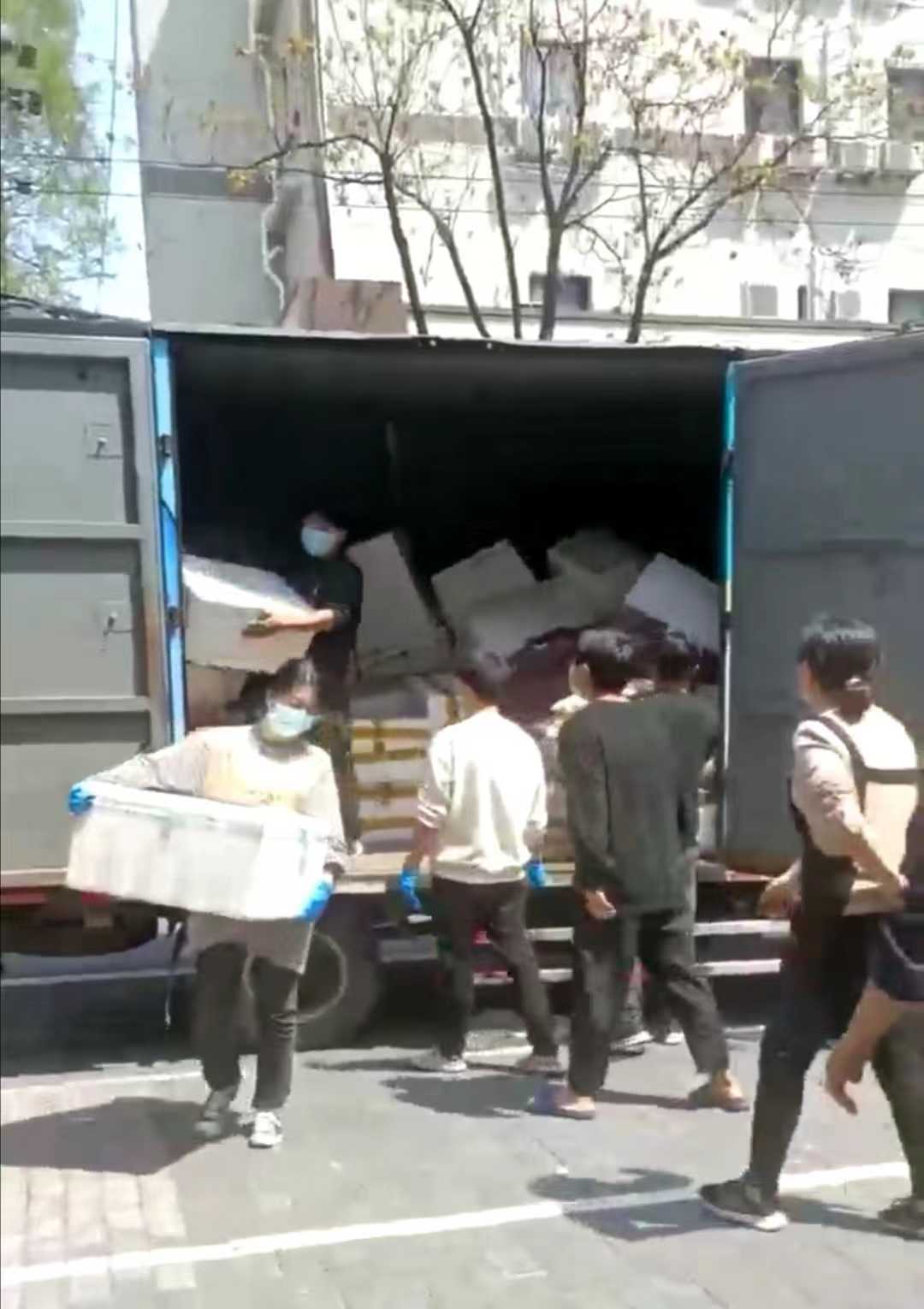 疫情期间,李建国和店员们搬运菜品。受访者供图