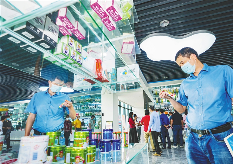 在洋浦保税港区综合服务大厅的跨境电商产品展示区，嘉宾了解跨境电商产品。海南日报记者 陈元才 摄