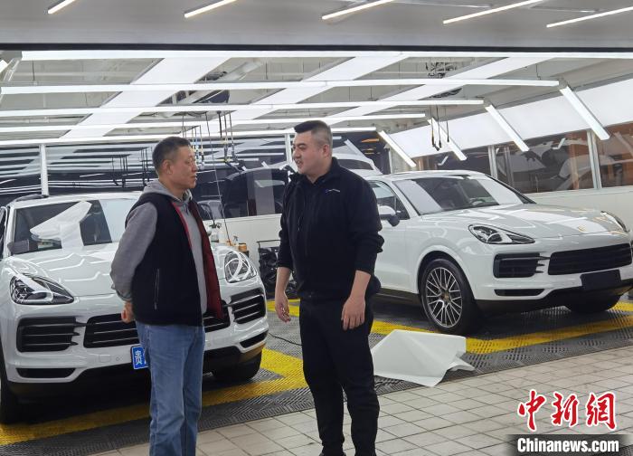 图为郭书廷(右)与进店客户交流。 周燕玲 摄