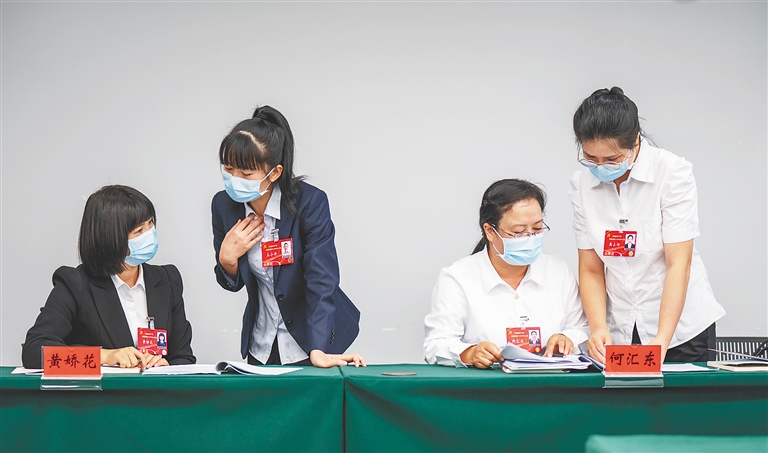 来自三亚的基层党代表黄娇花、王小丹、何汇东、高土玲（从左到右）认真审议党代会报告。 海南日报记者 袁琛 摄