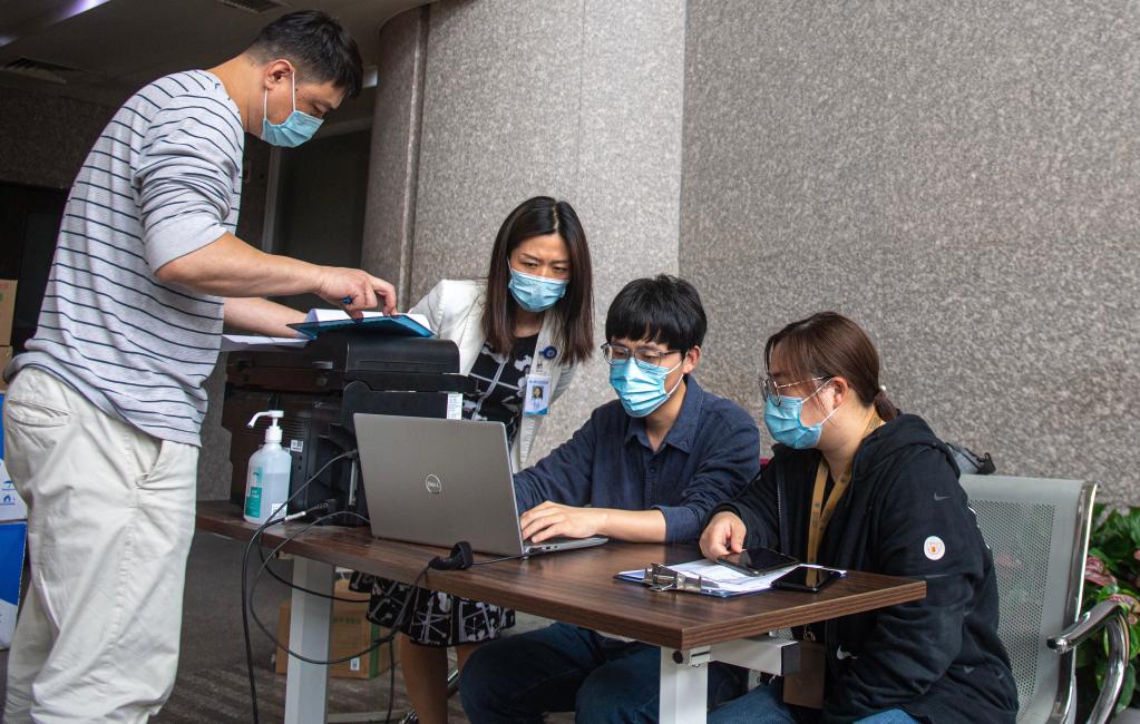 袁方(左二)与工作人员核对物资清单。新华社记者 江汉 摄