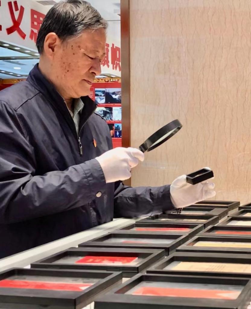 在共青团博物馆，陆君祥正在整理他的藏品。（新华社记者 高铭摄）