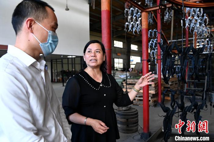 陈美华向来访的金融机构工作人员介绍企业生产情况。 张金川 摄