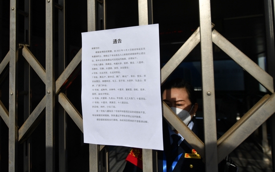 车站工作人员在门内值守,向市民解释出入口临时封闭的情况。新京报记者 王贵彬 摄