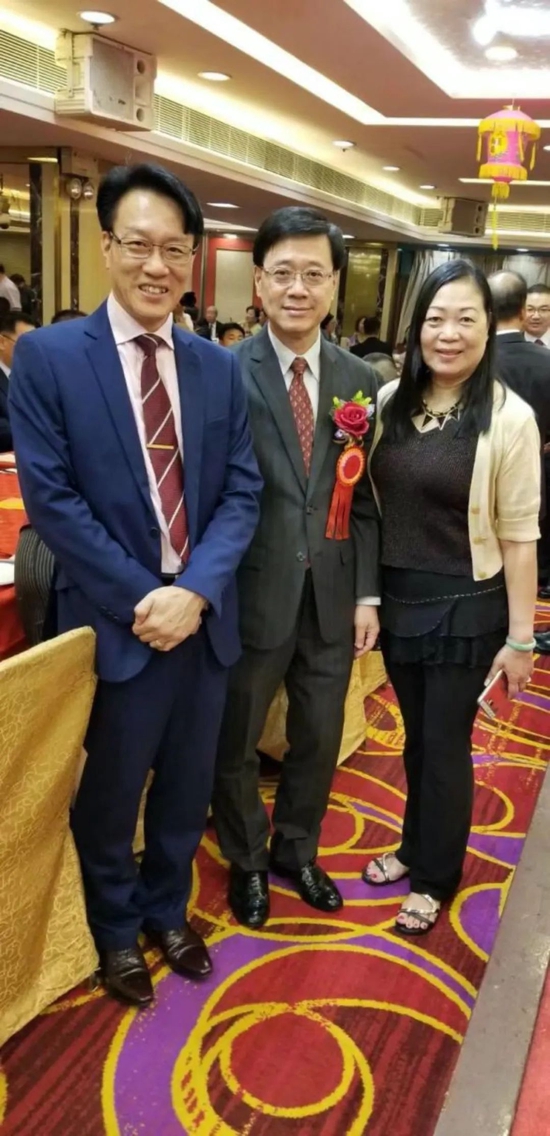 ·2017年,李家超(中)与校长黄锦耀(左)、校友何女士(右)在香港五邑工商总会96周年晚宴上的合影。(受访者供图)