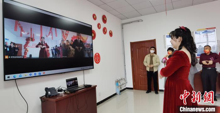 图为新人“隔空比心”,寓意交换信物。 徐巧明 摄