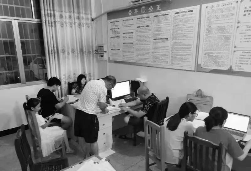 　　戴晓毛(右三)经常加班，孩子(左一)也跟在身边。图为戴晓毛在善塘村加班，核对社保信息。