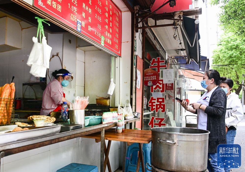 在上海市嘉定区新成路街道,居民在一家蛋饼店前排队(5月9日摄)。