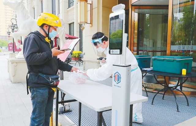 5月16日,外卖骑手在上海市宝山区一家饭店门口取餐准备派送。新华社记者 方喆 摄