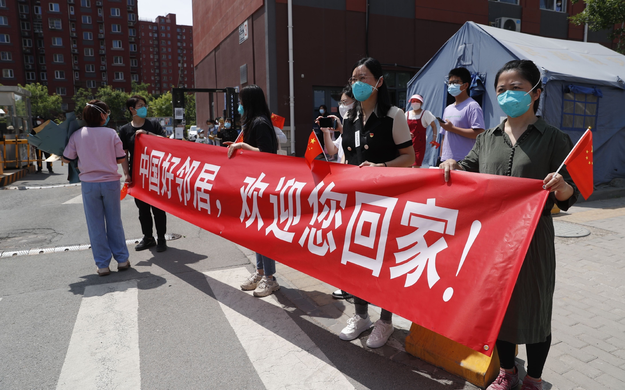 冠华苑小区外，居民拉着横幅，欢迎“中国好邻居”回家。新京报记者 侯少卿 摄