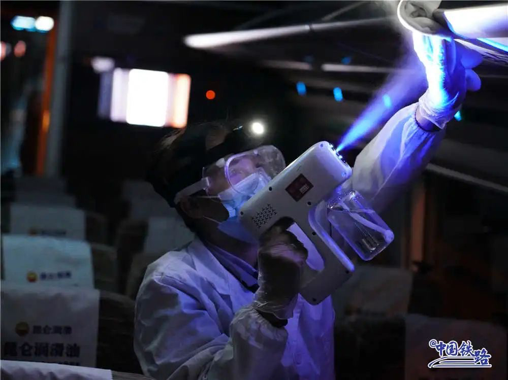 工作人员在上海入库和出库的动车组列车上,使用纳米蓝光消毒喷雾器进行消杀。