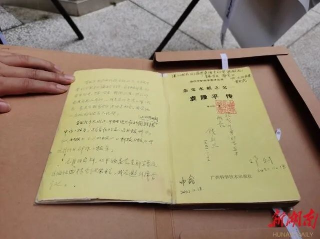 2022年5月20日,袁隆平院士首届学生、湖南杂交水稻研究中心原第一副主任谢长江,将《杂交水稻之父--袁隆平传》及袁隆平院士修改定稿的作者手稿捐赠给湖南农业大学。新湖南客户端 图