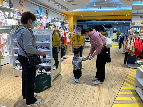 在金山万达广场的一家童装店，汤女士为孩子挑选衣物。&nbsp;&nbsp;本文图均为 上海金山区供图