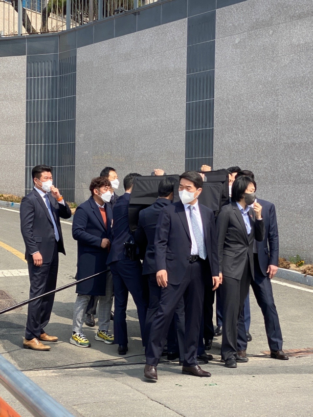 朴槿惠3月24日被扔酒瓶,保镖将其团团围住。(资料图)