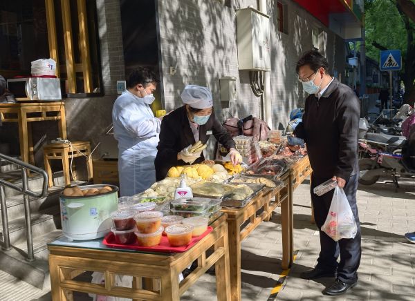 5月1日清晨,市民在北京佟麟阁路的庆丰包子铺和华天二友居肉饼店铺门前购买早餐(新华社发)